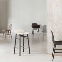 Stylish chairs in neutral tones: cream, gray, brown, and black with sleek designs, set in a modern interior.