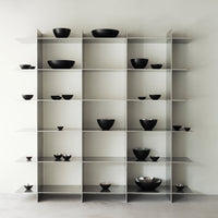 Modern shelving unit displaying sleek, minimalist black bowls against a clean, light backdrop. Ideal for contemporary decor.
