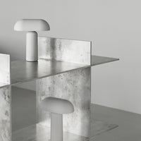 Sleek metallic structure with a smooth gray surface and minimalistic white lamp accents, featuring modern geometric patterns.