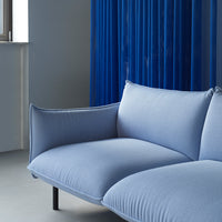 Soft blue sofa with subtle texture, paired with striking blue vertical lines in the background.
