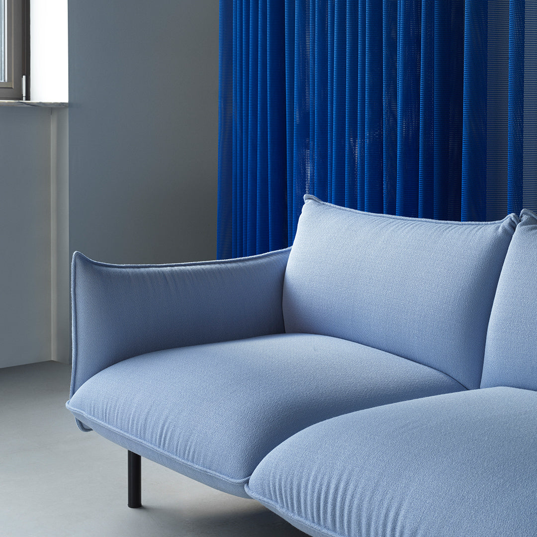 Soft blue sofa with subtle texture, paired with striking blue vertical lines in the background.