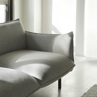 Soft gray fabric sofa with smooth contours and a minimalistic design, bathed in natural light. Perfect for modern decor.