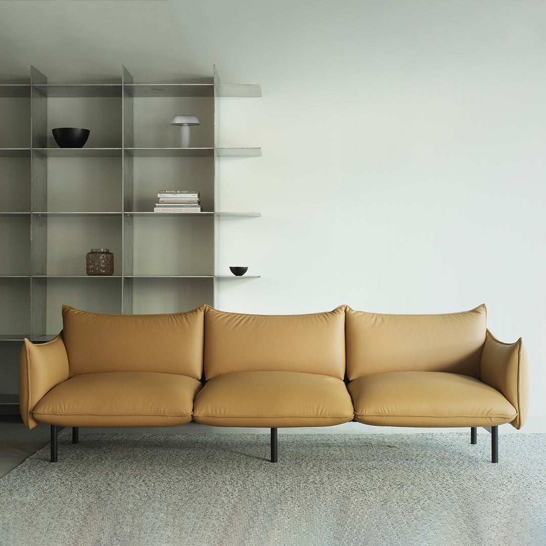 Tan leather sofa with smooth, modern lines against a minimalist backdrop. Subtle textures and neutral tones enhance elegance.