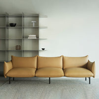 Tan leather sofa with smooth, modern lines against a minimalist backdrop. Subtle textures and neutral tones enhance elegance.