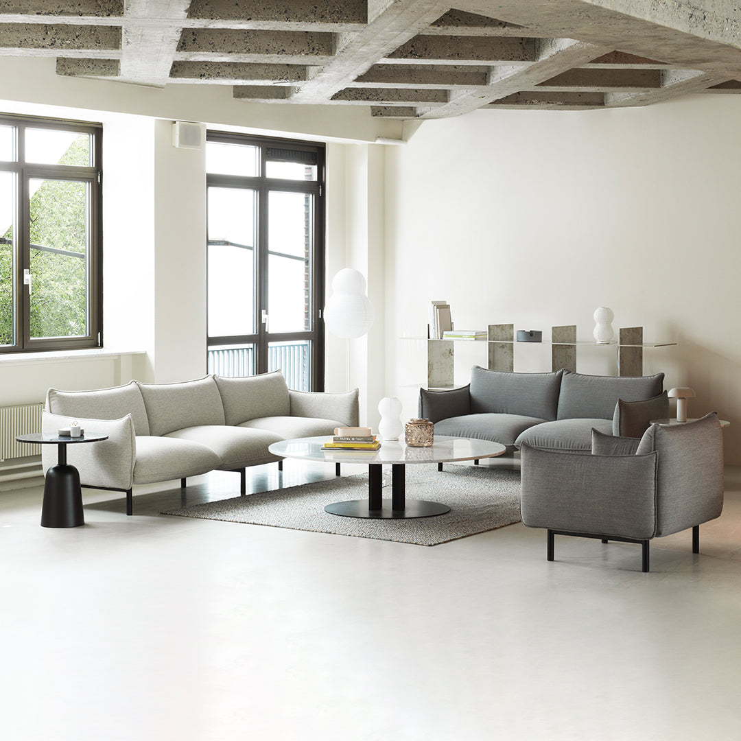 Modern minimalist living room featuring light gray and charcoal upholstery, complemented by subtle textures and smooth surfaces.
