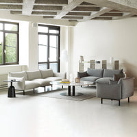 Modern minimalist living room featuring light gray and charcoal upholstery, complemented by subtle textures and smooth surfaces.