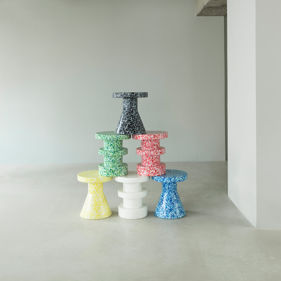 Colorful stack of patterned side tables in green, blue, red, yellow, and white with a modern design.