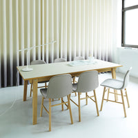Neutral beige and taupe tones with a gradient patterned wall; sleek white tabletop and soft gray chairs.