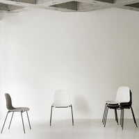 Modern chairs in black, white, and gray colors against a minimalist backdrop. Simple and elegant design.