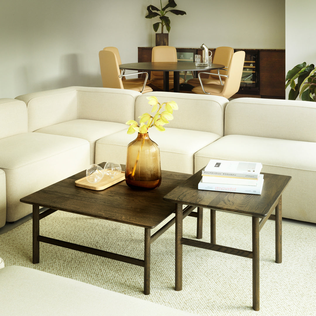 Set of two wood coffee tables with dark brown finish, complemented by a beige couch and minimalist decor.