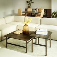 Set of two wood coffee tables with dark brown finish, complemented by a beige couch and minimalist decor.