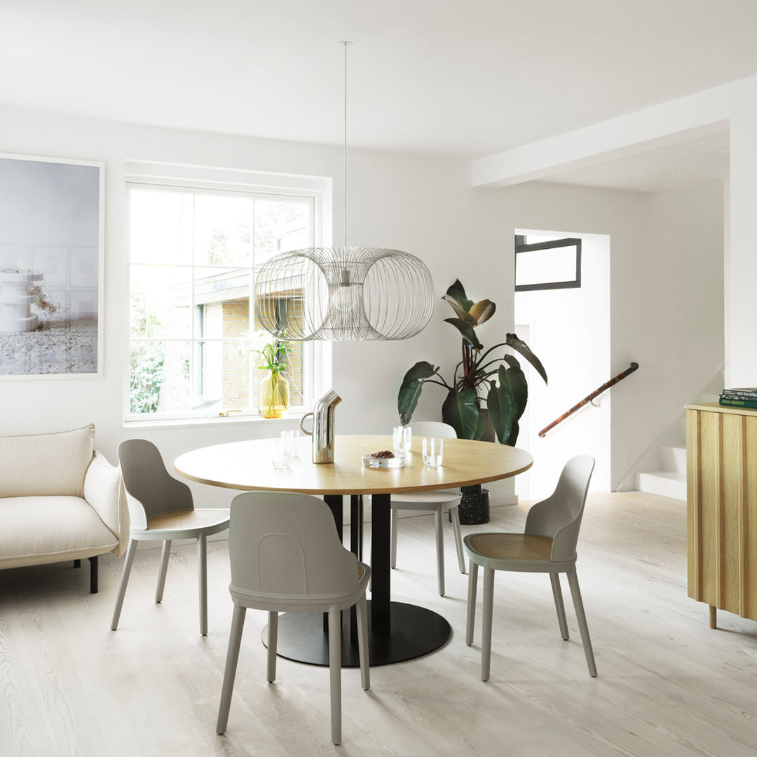 Modern dining room featuring a round wooden table, gray chairs, and a light, neutral color palette.