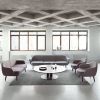 Modern living room featuring gray and light purple furniture with a circular black coffee table on a textured gray rug.