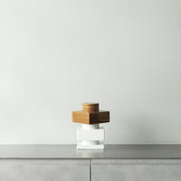 Stacked geometric boxes in brown and white atop a minimalist gray surface.