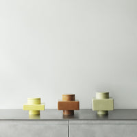 "Three geometric vases in yellow, brown, and pastel green against a minimalist background."