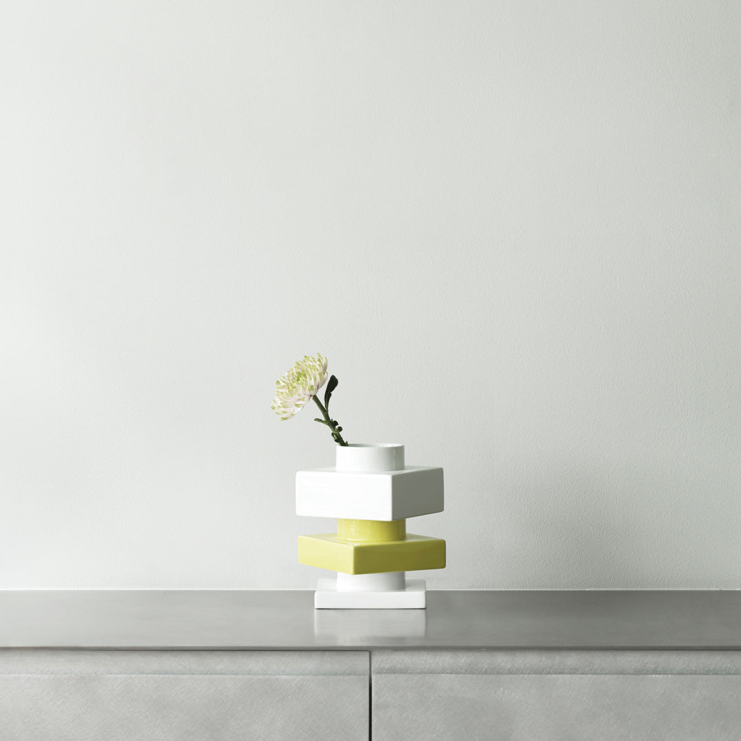 Modern stacked vase in white and vibrant yellow, showcasing sleek geometric patterns, perfect for contemporary decor.