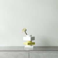 Modern stacked vase in white and vibrant yellow, showcasing sleek geometric patterns, perfect for contemporary decor.