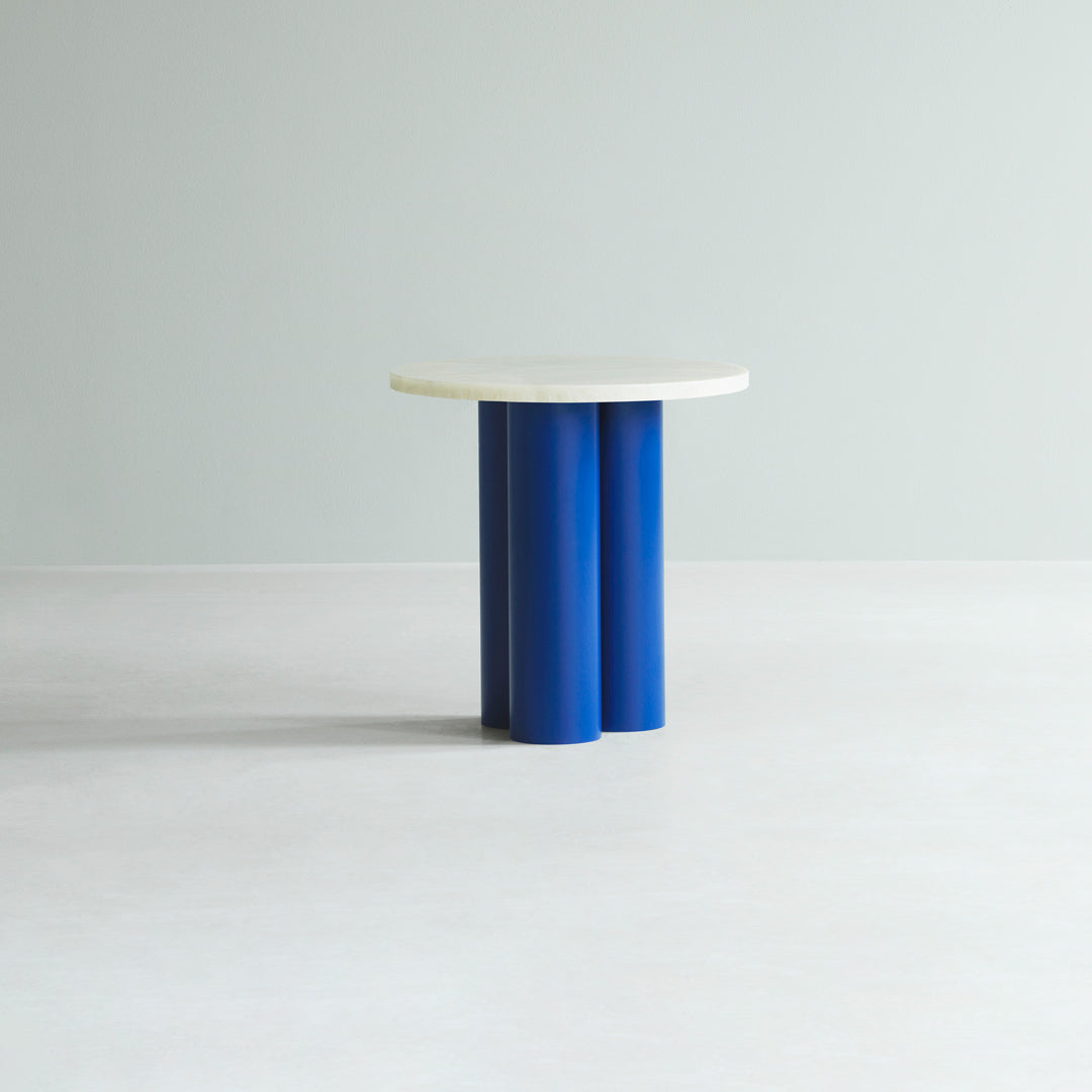 Round white tabletop on cylindrical blue legs, featuring a minimalist design against a light backdrop.