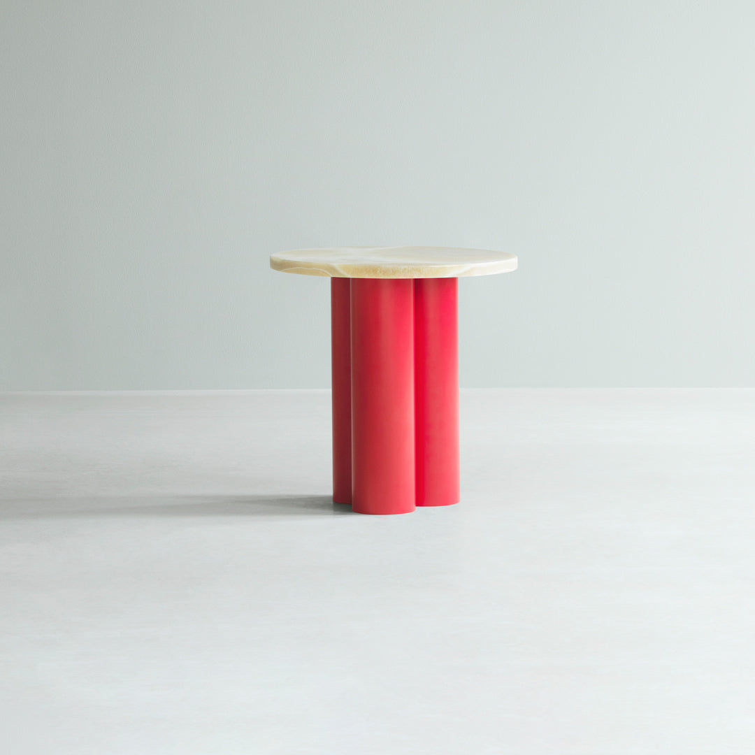 Red cylindrical base with a natural wood top on a light gray background. Modern design with bold color contrast.