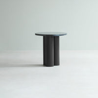 Round table with a smooth, blue-green top and matte black cylindrical legs, set against a light gray background.