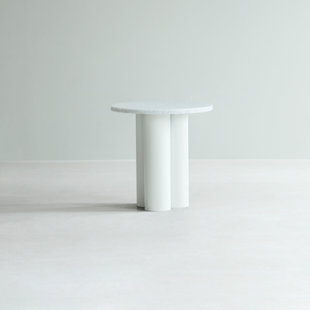 Modern round table in light gray with a smooth surface and cylindrical white legs, perfect for contemporary decor.