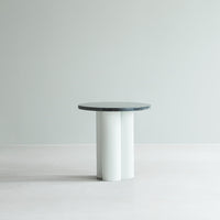 Round table with a gray marble top and white cylindrical base, set against a light gray background.