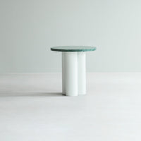 Round tabletop in green marble with a sleek white cylindrical base, perfect for modern decor.