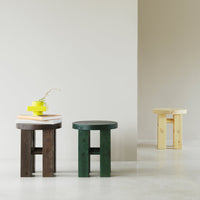 "Three wooden stools: dark brown, forest green, and light yellow. Simple, modern design with smooth finishes."