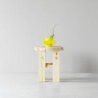Natural wood table with light yellow accents and a green plant for a fresh, modern look.