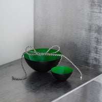Green and black nesting bowls with modern design, featuring smooth finishes and a sleek, minimalist aesthetic.