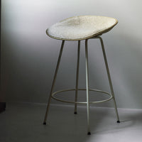 Modern white bar stool with a textured seat and sleek metal legs, perfect for contemporary decor.