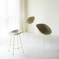 Modern chairs in soft beige tones, featuring sleek curved seats and light-colored legs, set against a minimalistic backdrop.