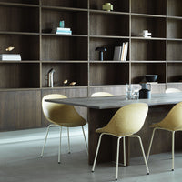 Modern dining area featuring a sleek wooden table, beige chairs, and a contrasting dark shelving unit.