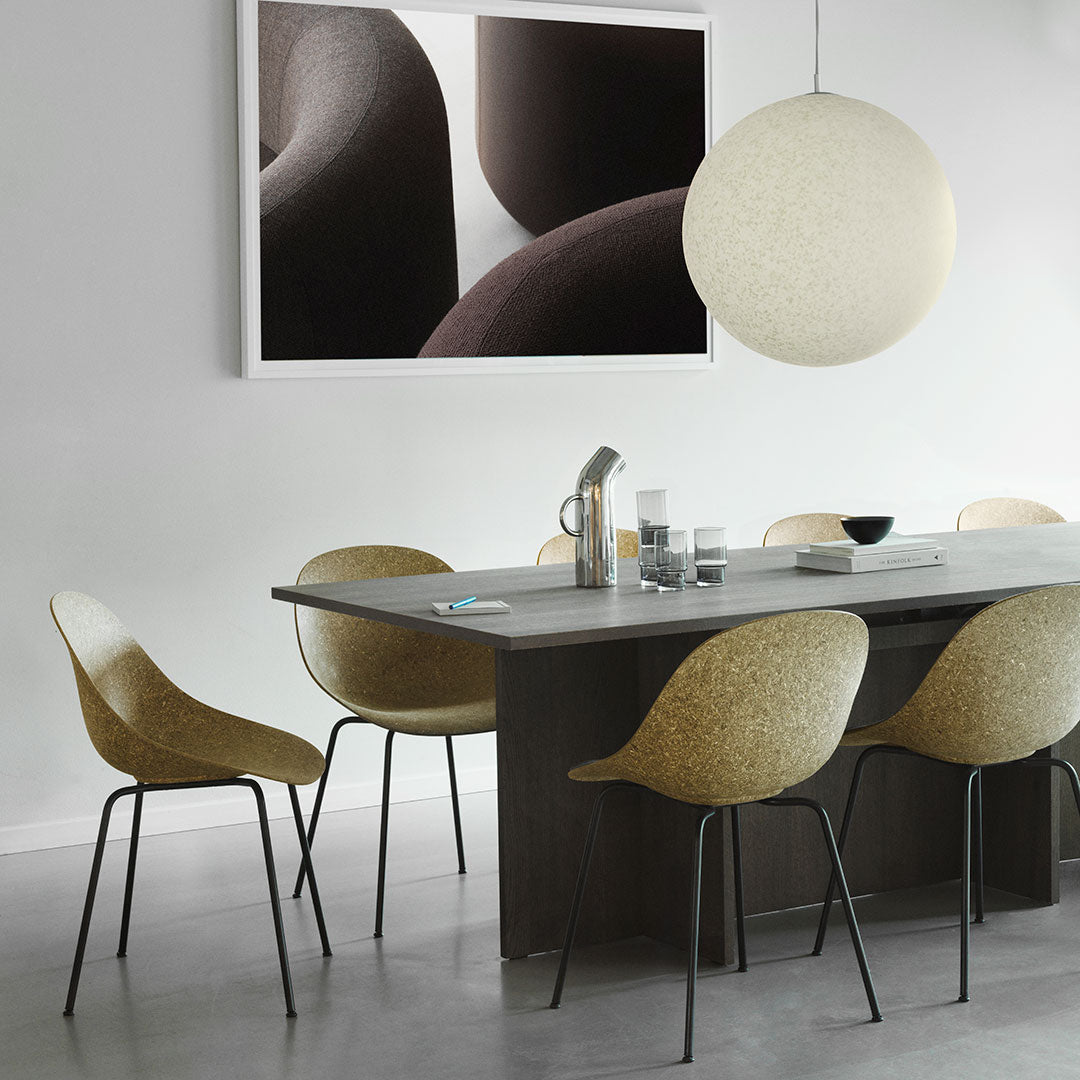 Modern dining room featuring beige molded chairs, a sleek gray table, and a large round light fixture.