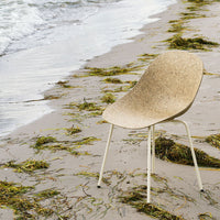 Beige chair with a textured finish, set against a sandy beach; subtle earth tones and natural patterns.