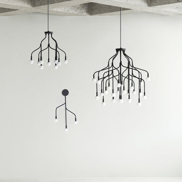 Black modern chandeliers with minimalist branch designs and white bulb accents, set against a neutral backdrop.