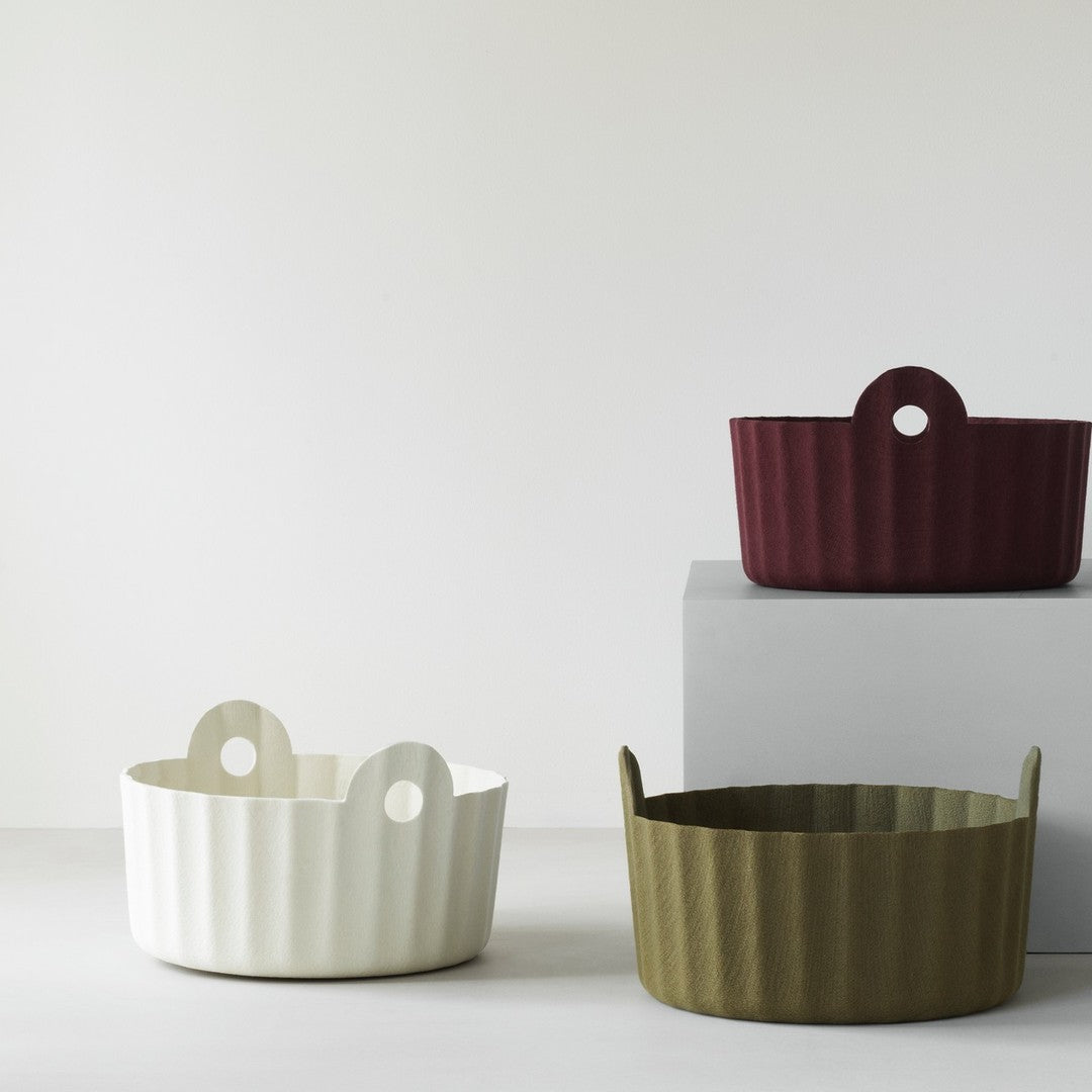 Textured baskets in white, olive green, and burgundy, featuring a ribbed pattern and unique handle design.