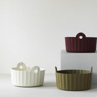 Textured baskets in white, olive green, and burgundy, featuring a ribbed pattern and unique handle design.