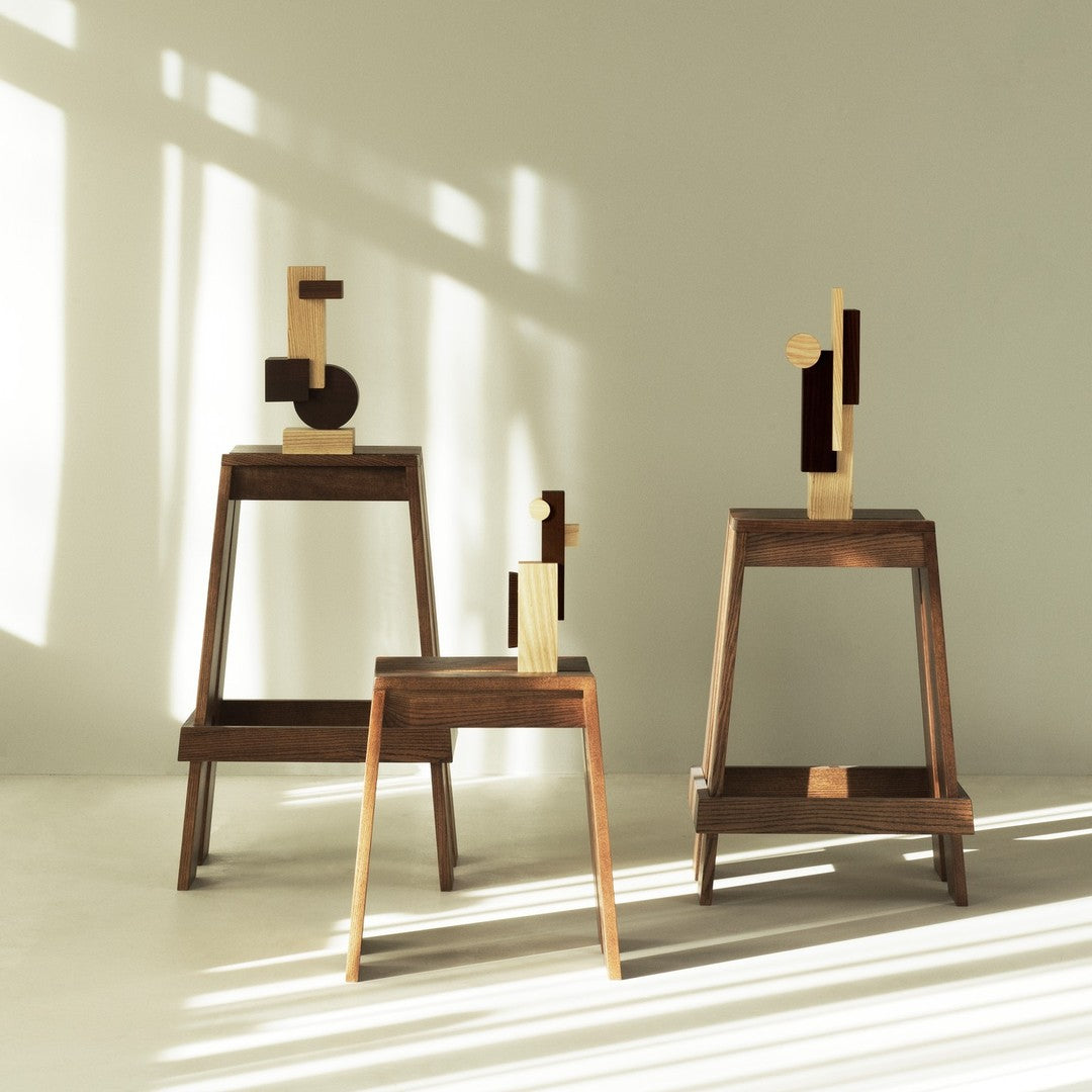 Elegant wooden sculptures in light and dark shades, featuring geometric patterns and contrasting finishes.