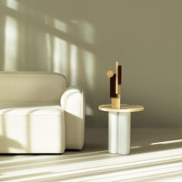 Modern beige sofa next to a light wood and white geometric table with natural wood accents. Soft shadows enhance the colors.