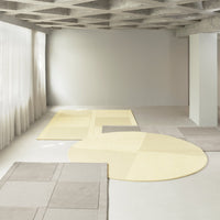 "Beige and light yellow rugs with geometric patterns on a neutral floor, creating a modern, minimalist aesthetic."