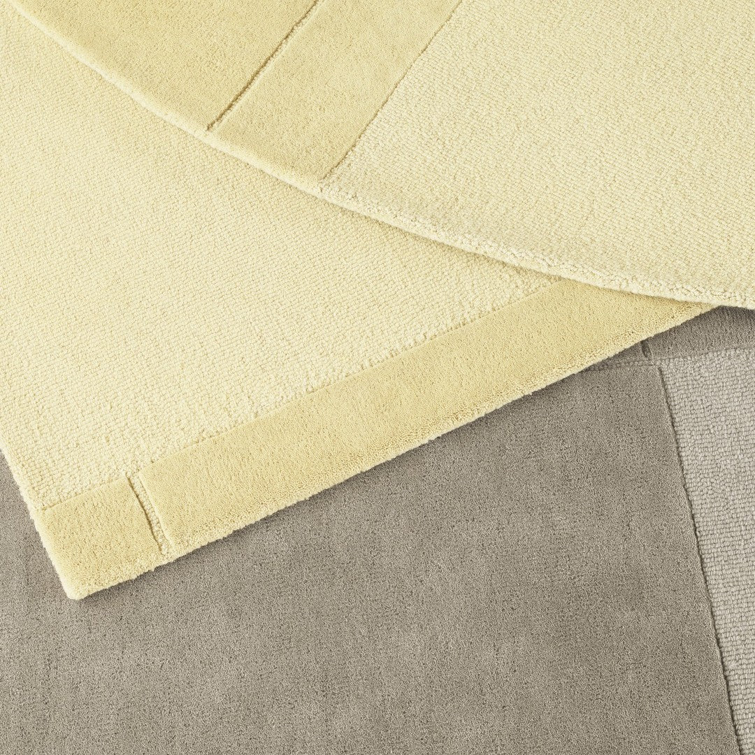 "Soft yellow and gray textured fabrics layered together, showcasing a cozy, minimalist design."