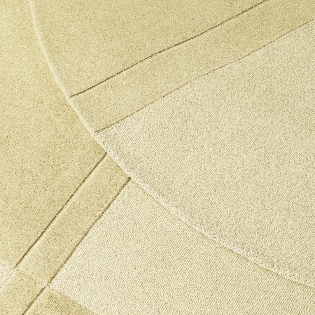 Creamy textured rug featuring overlapping circular and rectangular patterns in soft beige tones.