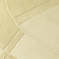 Creamy textured rug featuring overlapping circular and rectangular patterns in soft beige tones.