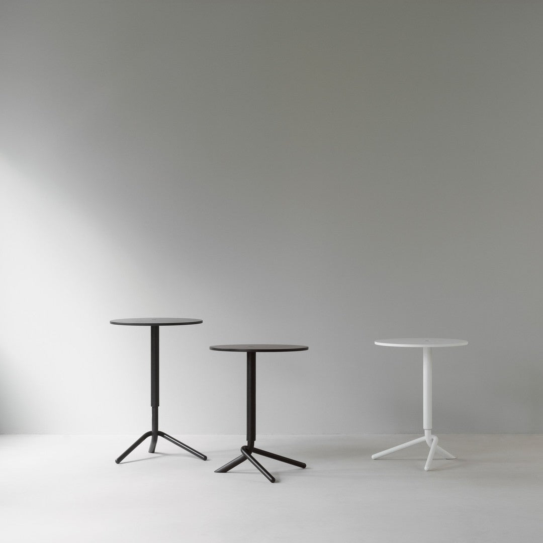 Three modern side tables in black and white, featuring sleek circular tops and tripod bases against a neutral background.
