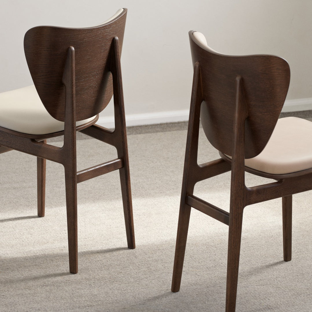 Brown wooden chairs with a sleek design and light beige upholstery, featuring smooth curves and clean lines.