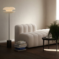"Textured white sofa with ribbed design, complemented by warm wooden tones and soft ambient lighting."
