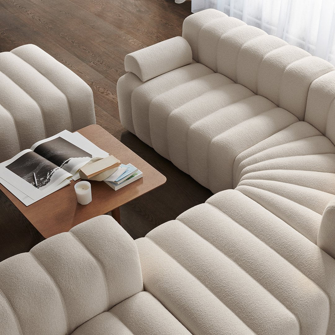 Beige textured couch with ribbed patterns and a light wooden coffee table, creating a cozy, modern living space.