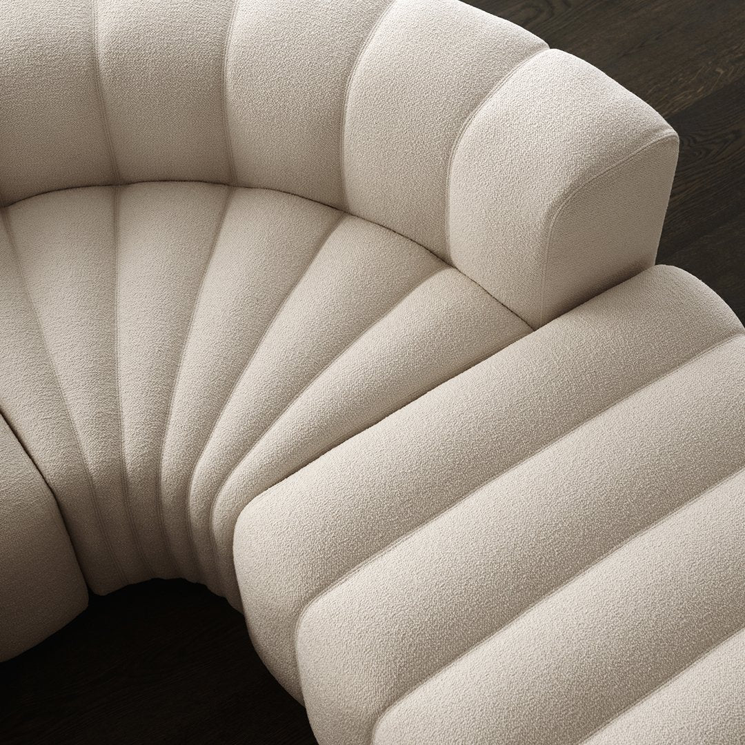 Beige curved couch with tufted wave pattern, showcasing a modern and inviting texture. Perfect for stylish interiors.