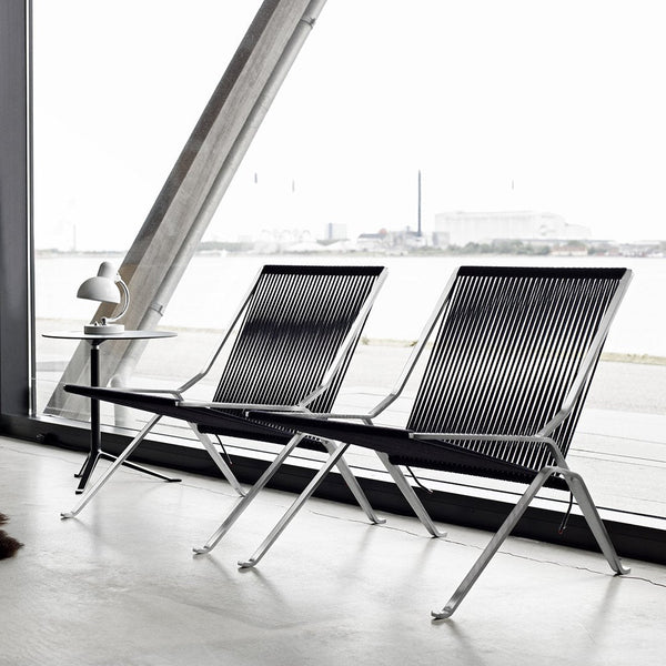 Modern black and white striped lounge chairs with sleek chrome frames, showcasing minimalistic design and elegance.